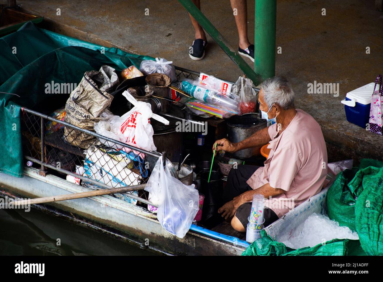 Les vieilles femmes thaïlandaises pagayer et faire de l'équitation bateaux en bois transportant et livrer le produit de réservoir de gaz à la boutique marchande dans le canal local Wat Takhian Floating Banque D'Images