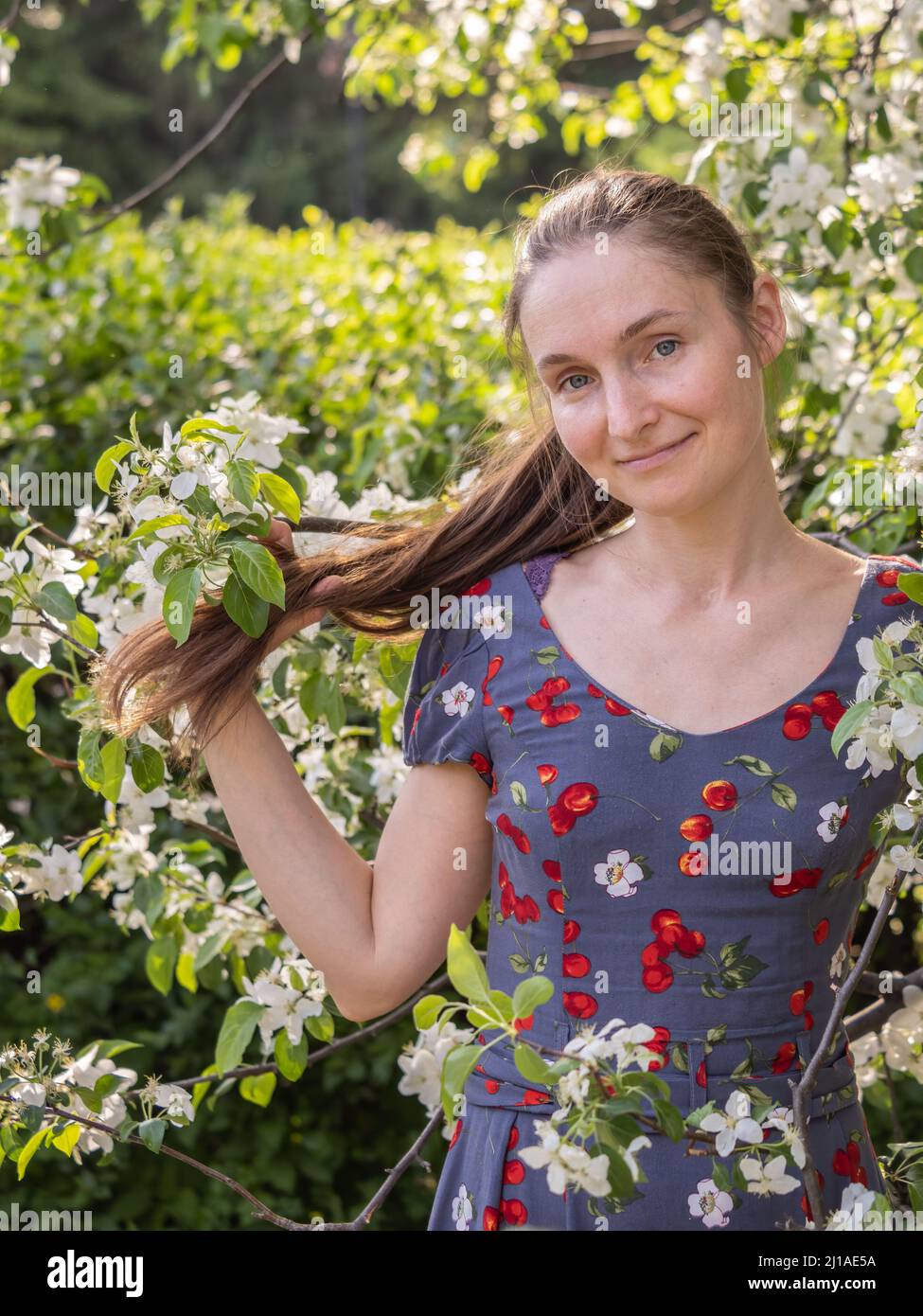 Belle jeune femme sans maquillage dans un parc de printemps parmi les arbres à fleurs.Gros plan