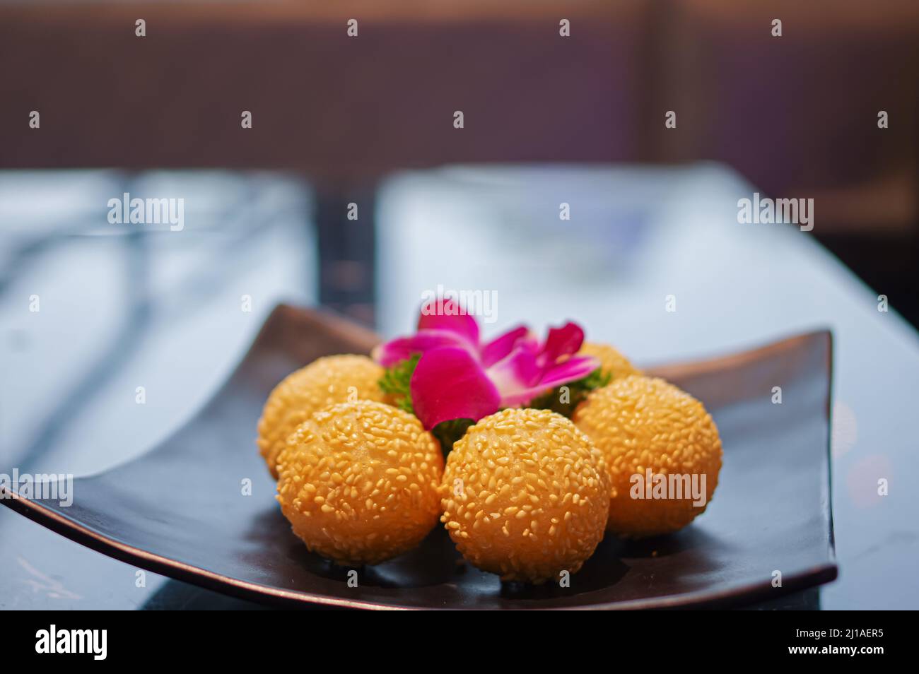 Boulettes de sésame frites croustillantes comme dessert sur une assiette noire Banque D'Images