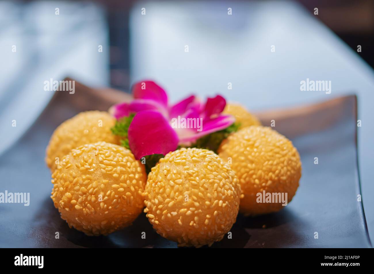 Boulettes de sésame frites croustillantes comme dessert sur une assiette noire Banque D'Images