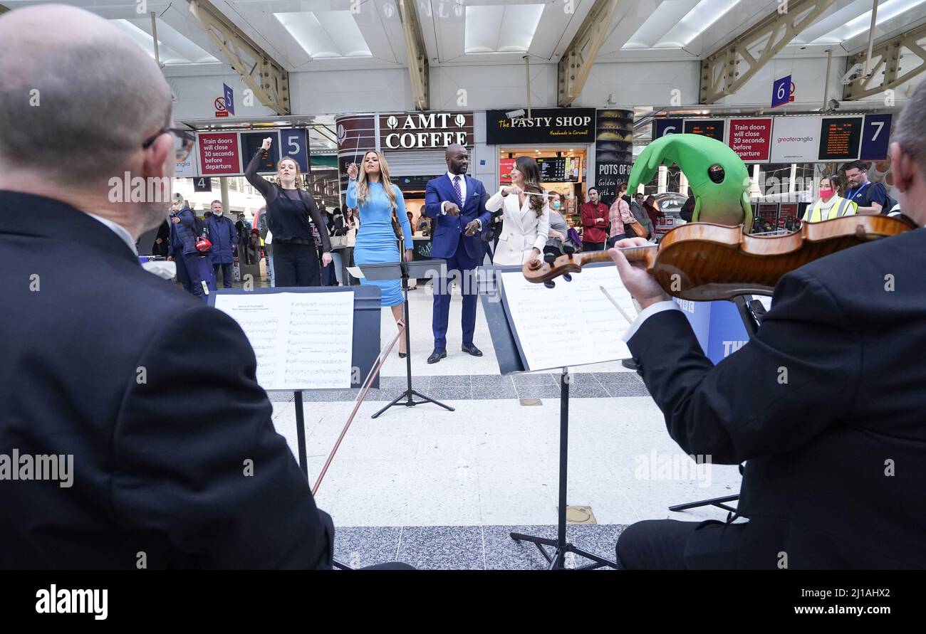 Le chef d'orchestre Chloe Rooke montre à Kathryn Burn, Tim Campbell et Harpreet Kaur comment diriger l'orchestre de concert de la BBC lorsqu'ils exécutent le thème de l'apprenti sur le hall de la gare de Liverpool Street à Londres avant la finale de jeudi soir. Date de la photo: Jeudi 24 mars 2022. Banque D'Images