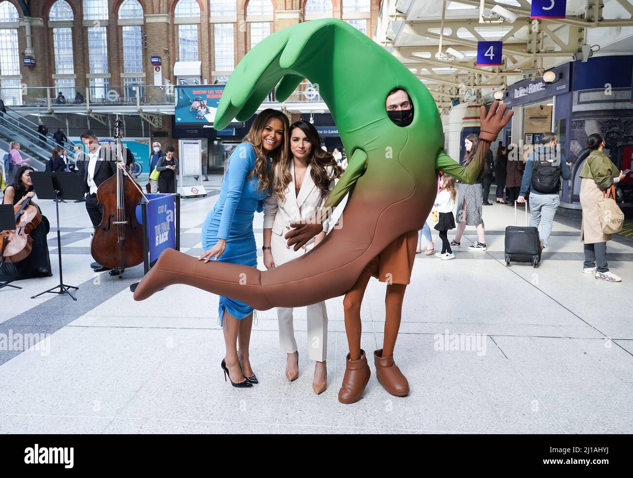 Kathryn Burn et Harpreet Kaur se tiennent à côté d'un logo qui a été conçu dans le premier épisode de l'apprenti sur le hall de la gare de Liverpool Street à Londres avant la finale de jeudi soir. Date de la photo: Jeudi 24 mars 2022. Banque D'Images