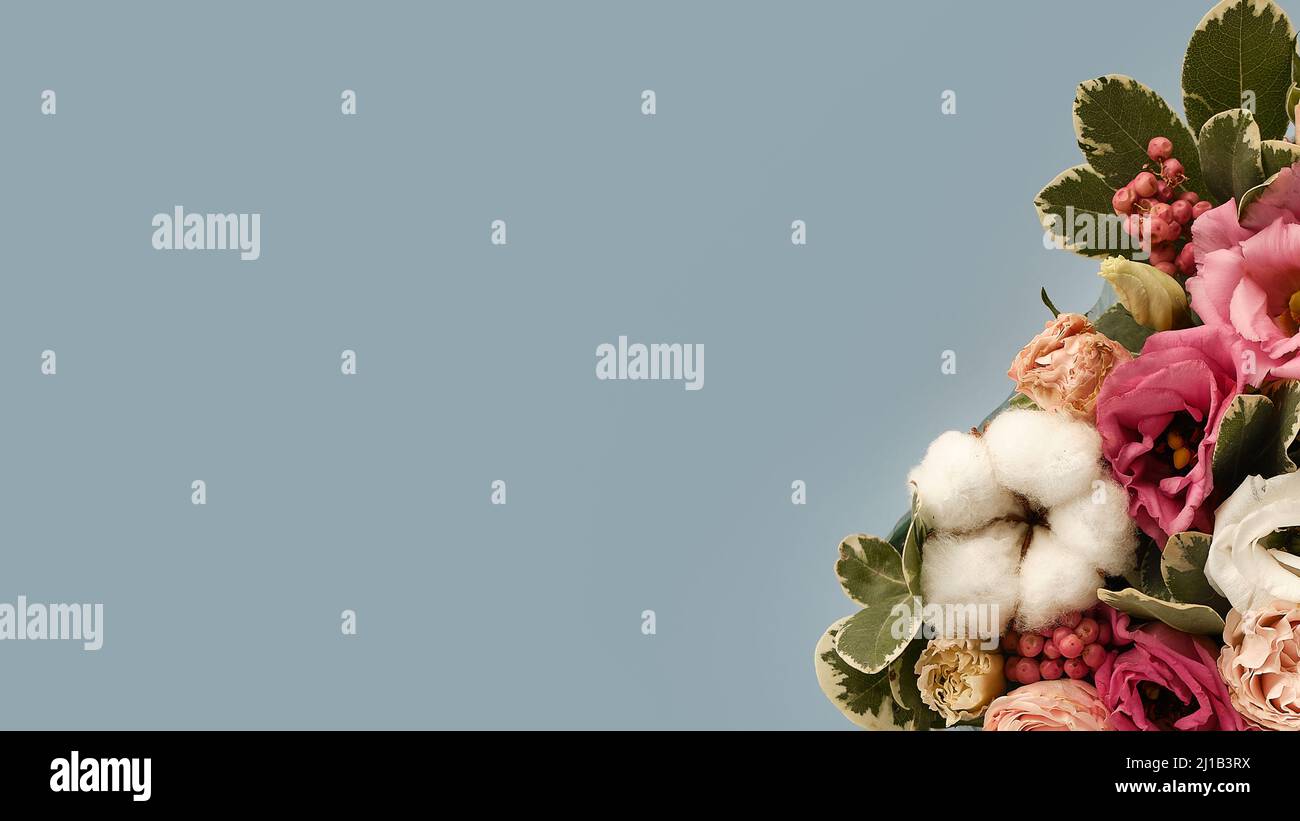 Bouquet de fleurs sur le côté dans un style rustique sur fond bleu. Fleurs de printemps. Conception géométrique. Bannière. Contexte de la présentation. Copier Banque D'Images