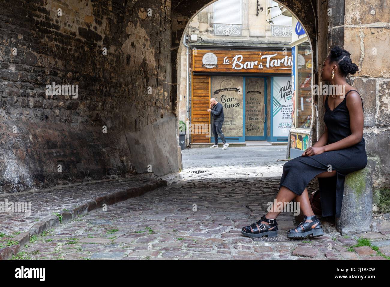 JEUNE FEMME NOIRE DANS UN PASSAGE SUR LA RUE DE LA GRENOUILLE, CAEN, CALVADOS, NORMANDIE, FRANCE Banque D'Images
