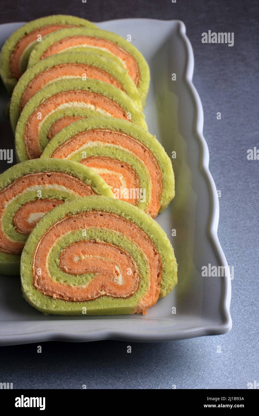 Bolu Gulung ou roulé gâteau Pandan et fraise à la crème de vanille. Tranché. Servi sur fond blanc, espace de copie Banque D'Images