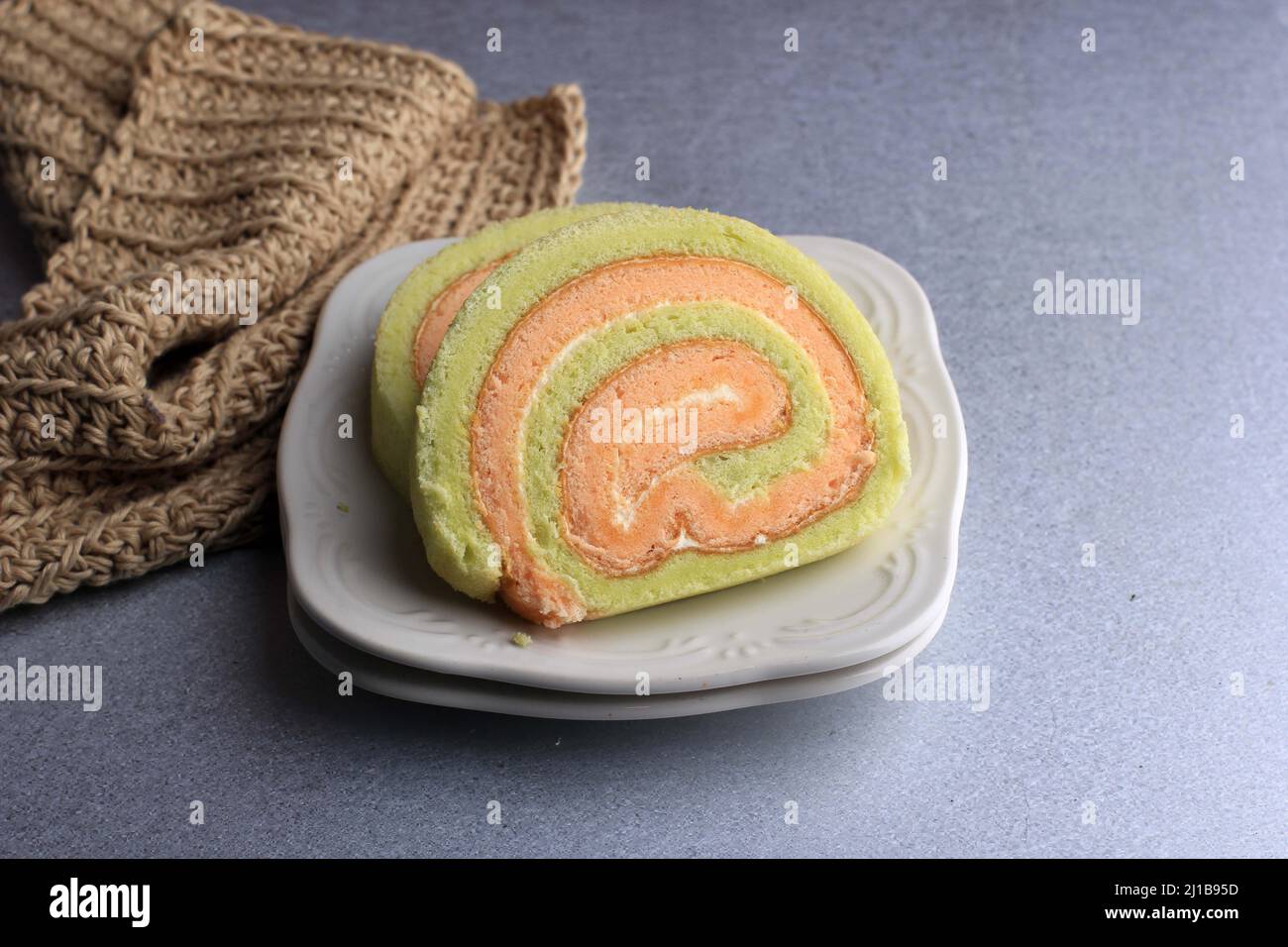 Bolu Gulung ou roulé gâteau Pandan et fraise à la crème de vanille. Tranché. Servi sur fond blanc, espace de copie Banque D'Images
