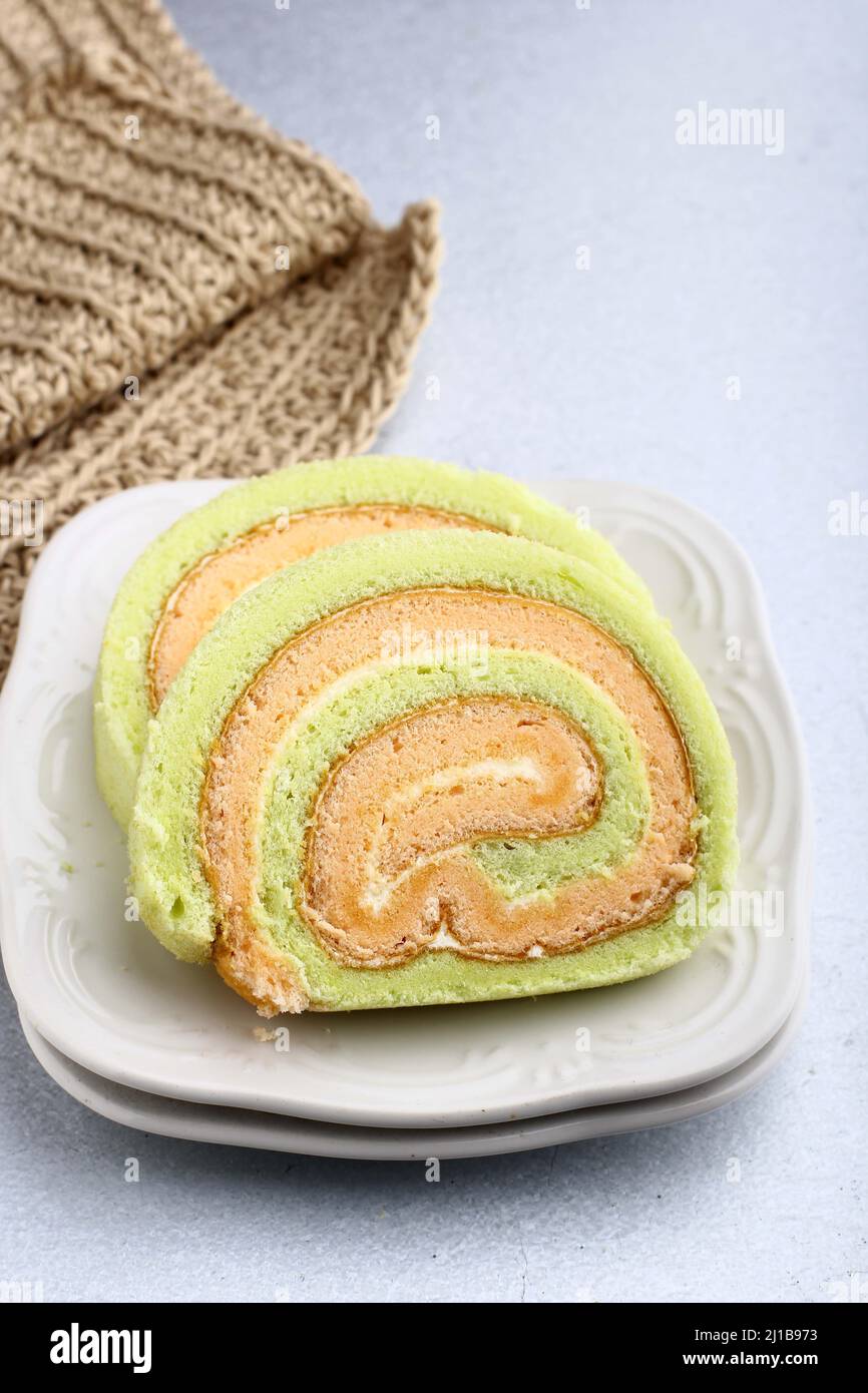 Bolu Gulung ou roulé gâteau Pandan et fraise à la crème de vanille. Tranché. Servi sur fond blanc, espace de copie Banque D'Images