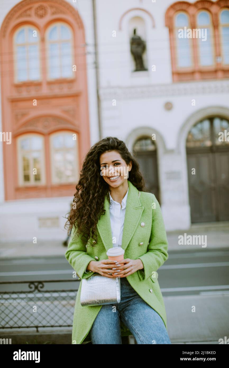 Une jolie jeune femme dans la rue qui tient un café à emporter Banque D'Images