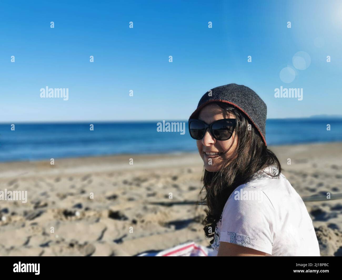 La jolie femme espagnole brune avec des lunettes de soleil, appréciant la  paix et le calme sur la plage Photo Stock - Alamy