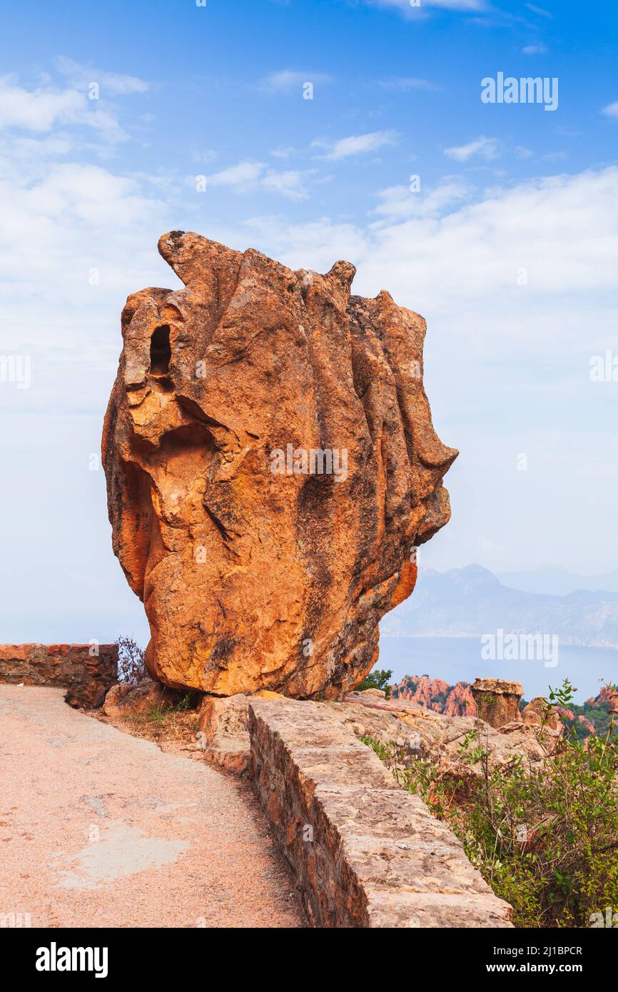 Une immense pierre rouge se dresse sur une route à Calanques de Piana. Corse, France. Photo verticale Banque D'Images
