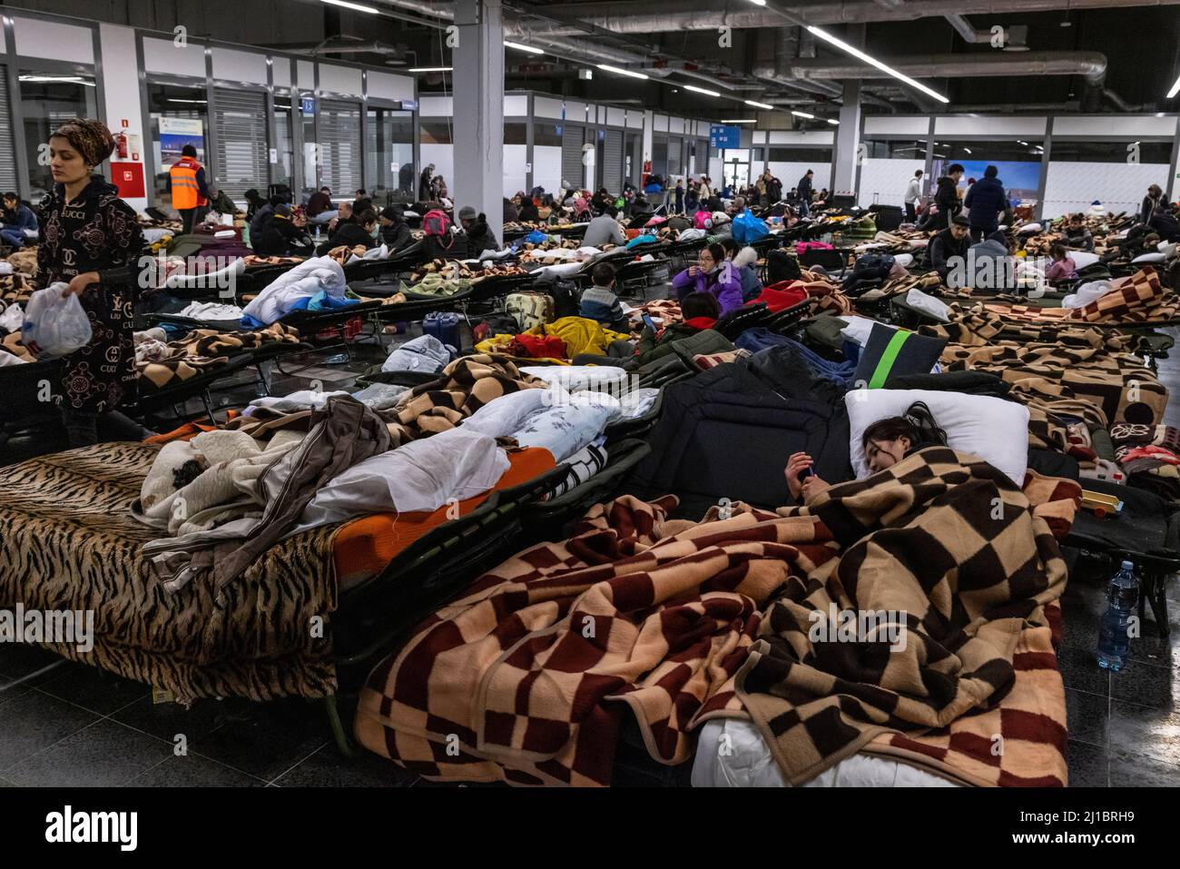 Les réfugiés d'Ukraine ont atteint le point central de collecte des réfugiés dans un centre logistique près de Korczowa, dans la zone frontalière entre la Pologne et l'Ukraine. Ici, ils peuvent se reposer sur les lits bébé fournis. Ici, ils sont également fournis avec de la nourriture et des vêtements, puis transportés plus loin en bus vers d'autres villes. Banque D'Images
