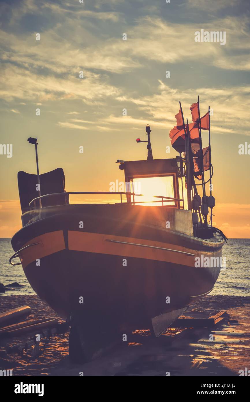 Belle vue le matin sur le bord de mer polonais à Gdynia. Bateau sur une plage de sable le matin. Photo de style vintage. Banque D'Images