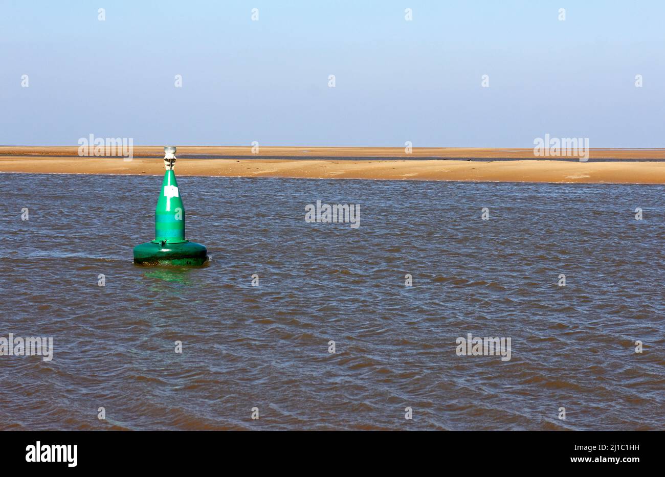 Une bouée marqueur de chenal dans la course, dans une marée basse dans le nord du Norfolk, menant au port de Wells-Next-the-Sea, Norfolk, Angleterre, Royaume-Uni. Banque D'Images