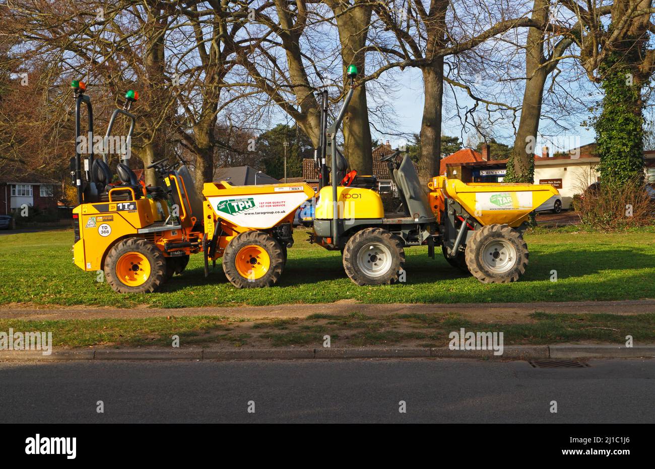 Une paire de camions-citernes jaunes garés hors route sur un petit vert dans une zone résidentielle du Borough de Hellesdon, Norfolk, Angleterre, Royaume-Uni. Banque D'Images