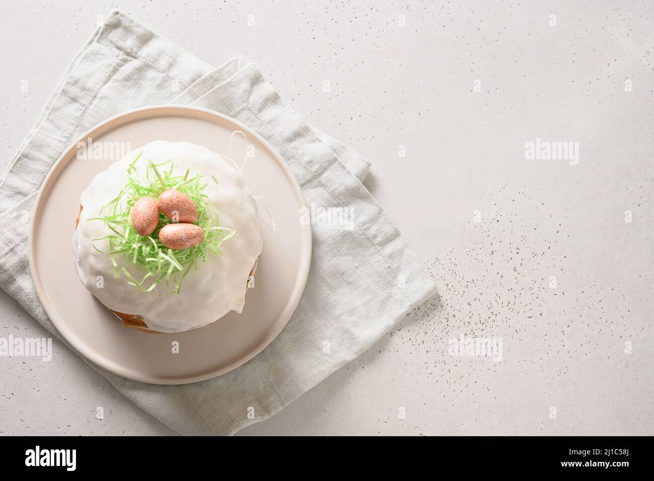 Gâteau de Pâques ou kulich décoré nid avec des œufs roses sur fond blanc. Espace pour le texte. Vue de dessus. Banque D'Images