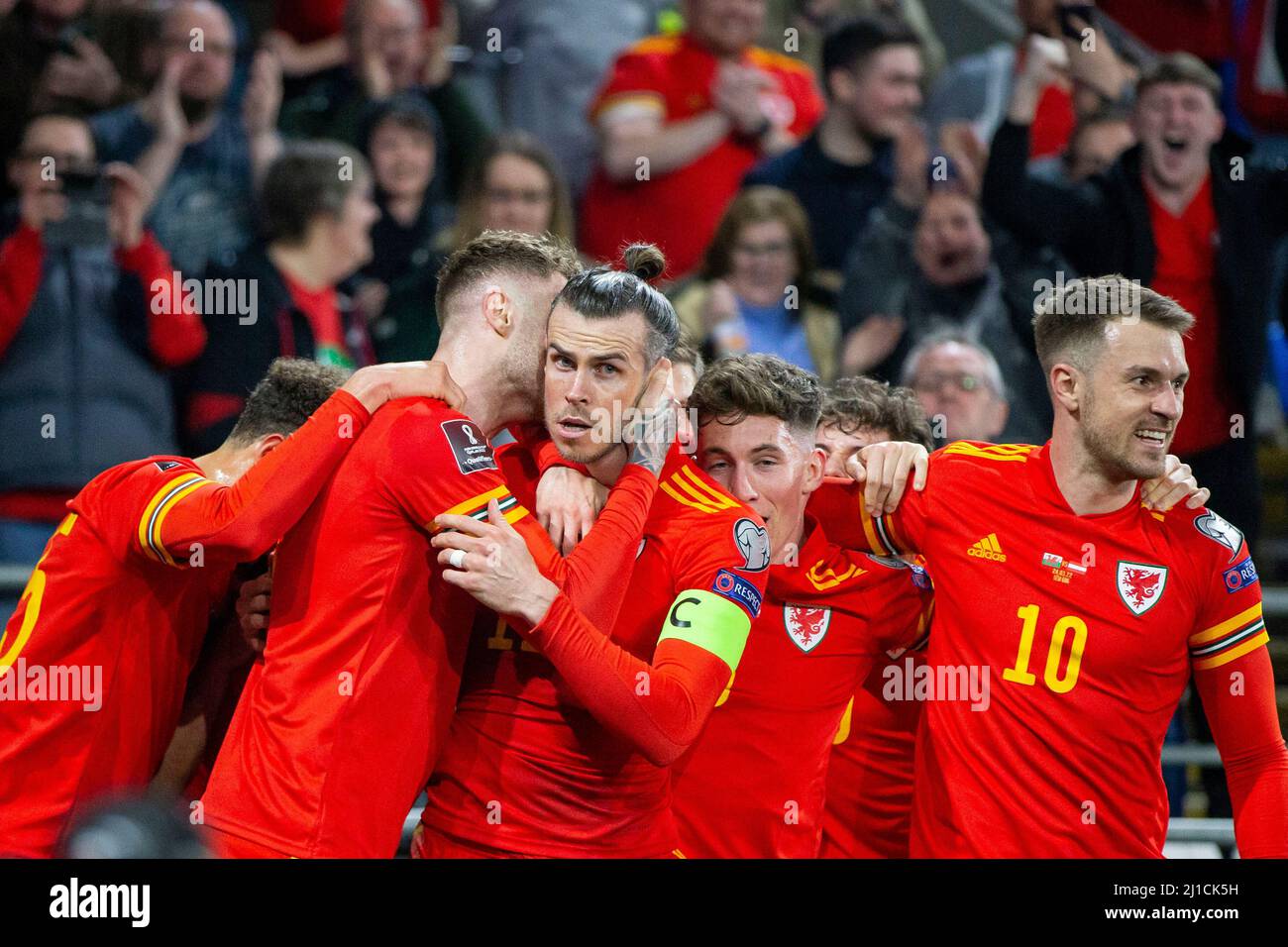 Cardiff, pays de Galles, Royaume-Uni. 24th mars 2022. Gareth Bale du pays de Galles est attrapé par les coéquipiers après avoir marquant le but d'ouverture de son équipe avec un coup de pied gratuit lors du match de demi-finale de la coupe du monde 2022 entre le pays de Galles et l'Autriche au stade de Cardiff City. Crédit : Mark Hawkins/Alay Live News Banque D'Images