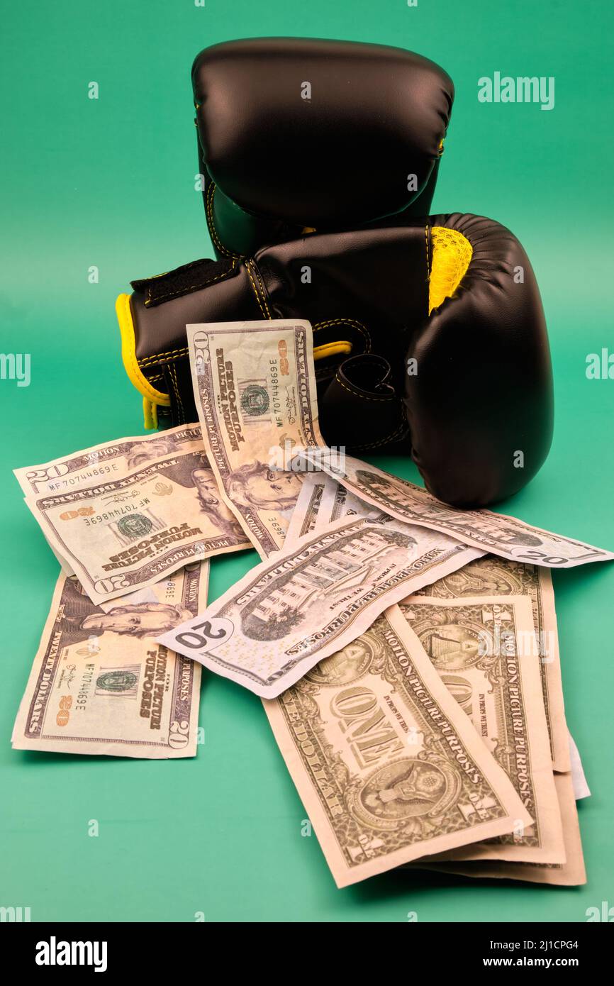 gants de boxe avec beaucoup de dollars sur fond vert Banque D'Images