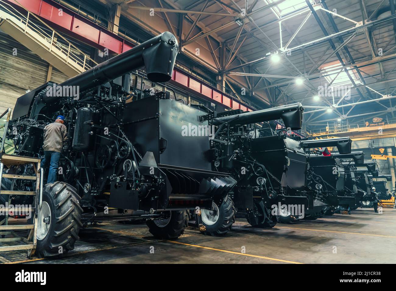 Tracteurs agricoles ou moissonneuses-batteuses dans une usine de machines industrielles grand hangar ou garage d'entrepôt. Banque D'Images