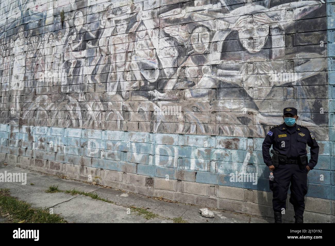 San Salvador, El Salvador. 24th mars 2022. Un policier se trouve à côté d'une fresque représentant Saint Oscar Romero. Le 24th 1980 mars, l'archevêque Oscar Romero a été assassiné par des escadrons de la mort alors qu'il présidait une messe commémorative à la chapelle Divina Providencia. (Photo de Camilo Freedman/SOPA Images/Sipa USA) crédit: SIPA USA/Alay Live News Banque D'Images