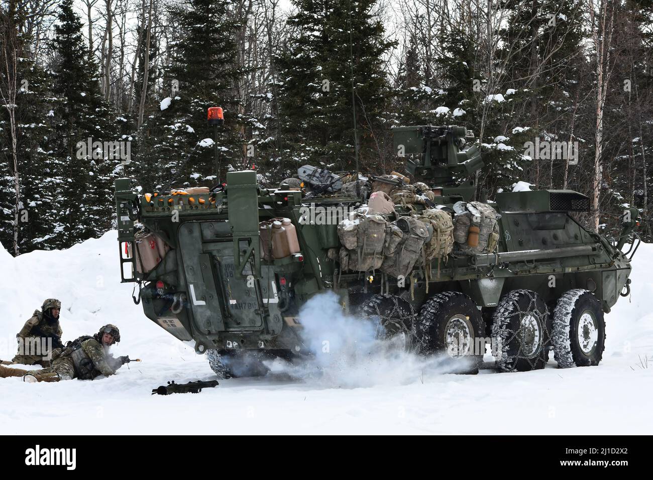 Un simulateur de grenade explose à côté d'un véhicule Stryker du 3rd Bataillon, 21st Infantry Regiment, dans la zone d'entraînement de Donnelly, au cours du joint Pacific multinational Readiness Centre 22-02, le 22 mars 2022. Cet exercice est conçu pour valider l’entraînement, la préparation et les capacités par temps froid de l’équipe de combat de la Brigade Stryker de l’Alaska 1st de l’Armée américaine, 25th de la Division d’infanterie. (Photo de l'armée/John Pennell) Banque D'Images