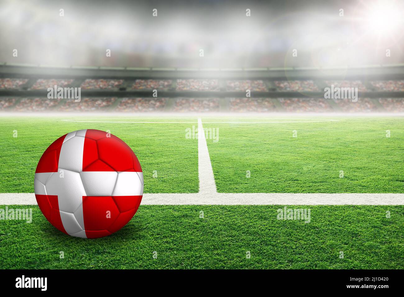 Football dans un stade en plein air lumineux avec drapeau peint du Danemark. Concentrez-vous sur le premier plan et le ballon de football avec une faible profondeur de champ sur l'arrière-plan A. Banque D'Images