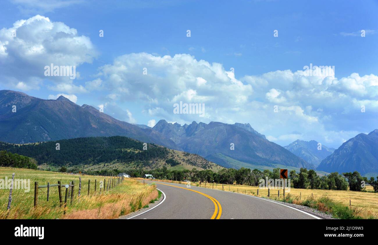 La route de campagne tourne vers les magnifiques montagnes d'Absaroka dans la vallée de Happy, Montana. Banque D'Images