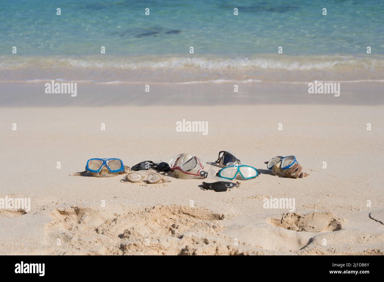 Des lunettes de natation dans le sable près de l'eau sur une plage ensoleillée. Masques de natation, lunettes de protection. Lunettes perdues et trouvées. Hawaï, États-Unis Banque D'Images