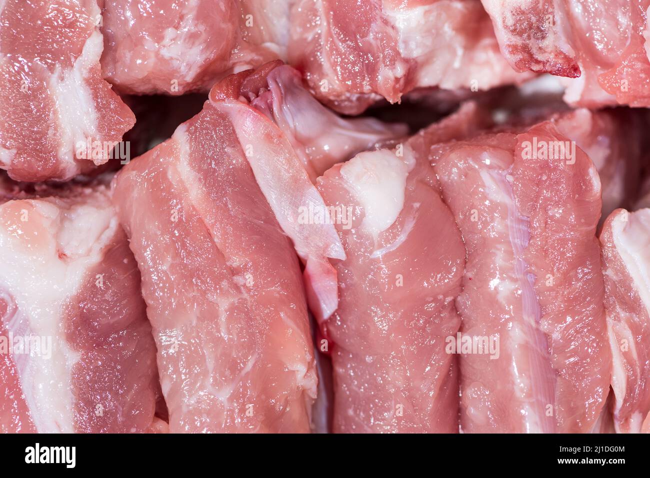 Gros plan vue de dessus pack morceaux de viande crue de filet de porc sur l'os, porc rouge frais avec graisse blanche de côte de porc, couper en morceaux et les mettre dans une rangée Banque D'Images