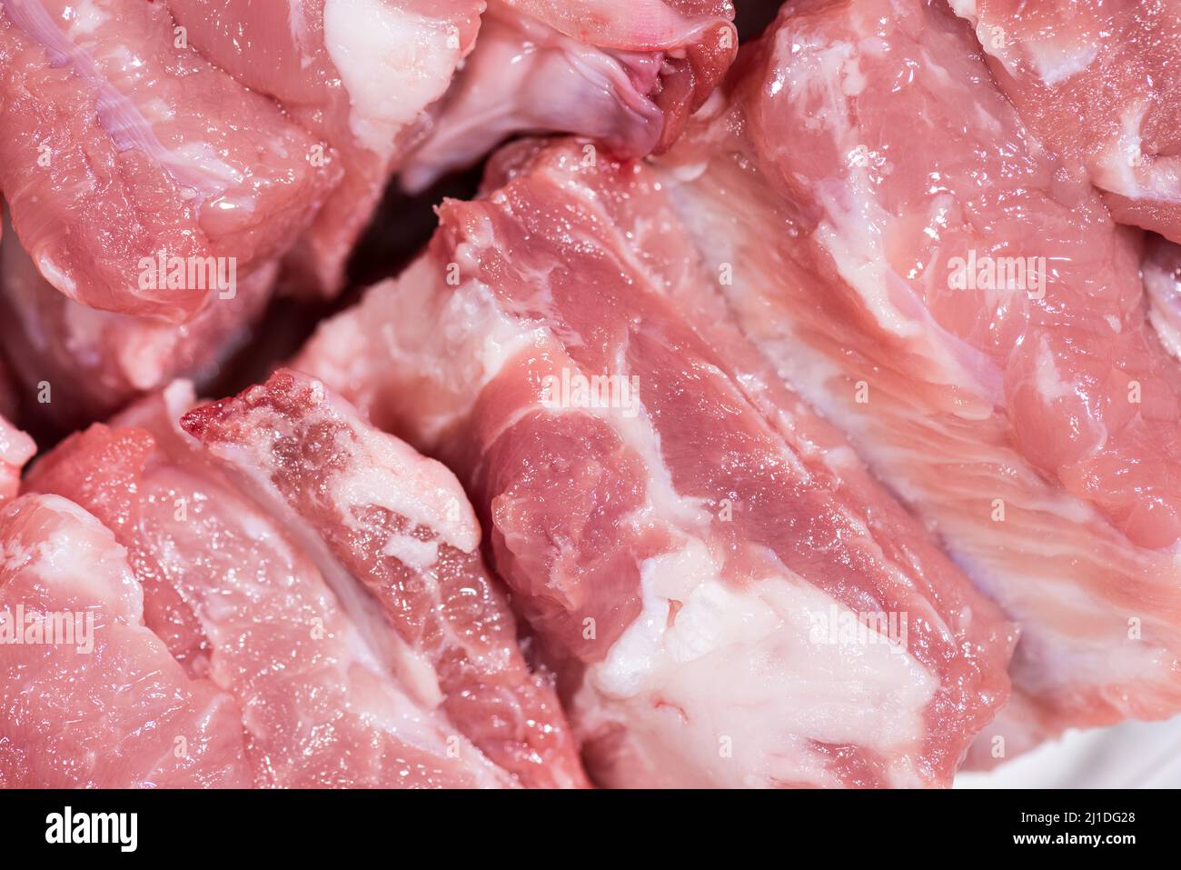 Gros plan vue de dessus pack morceaux de viande crue de filet de porc sur l'os, porc rouge frais avec graisse blanche de côte de porc, couper en morceaux et les mettre dans une rangée Banque D'Images