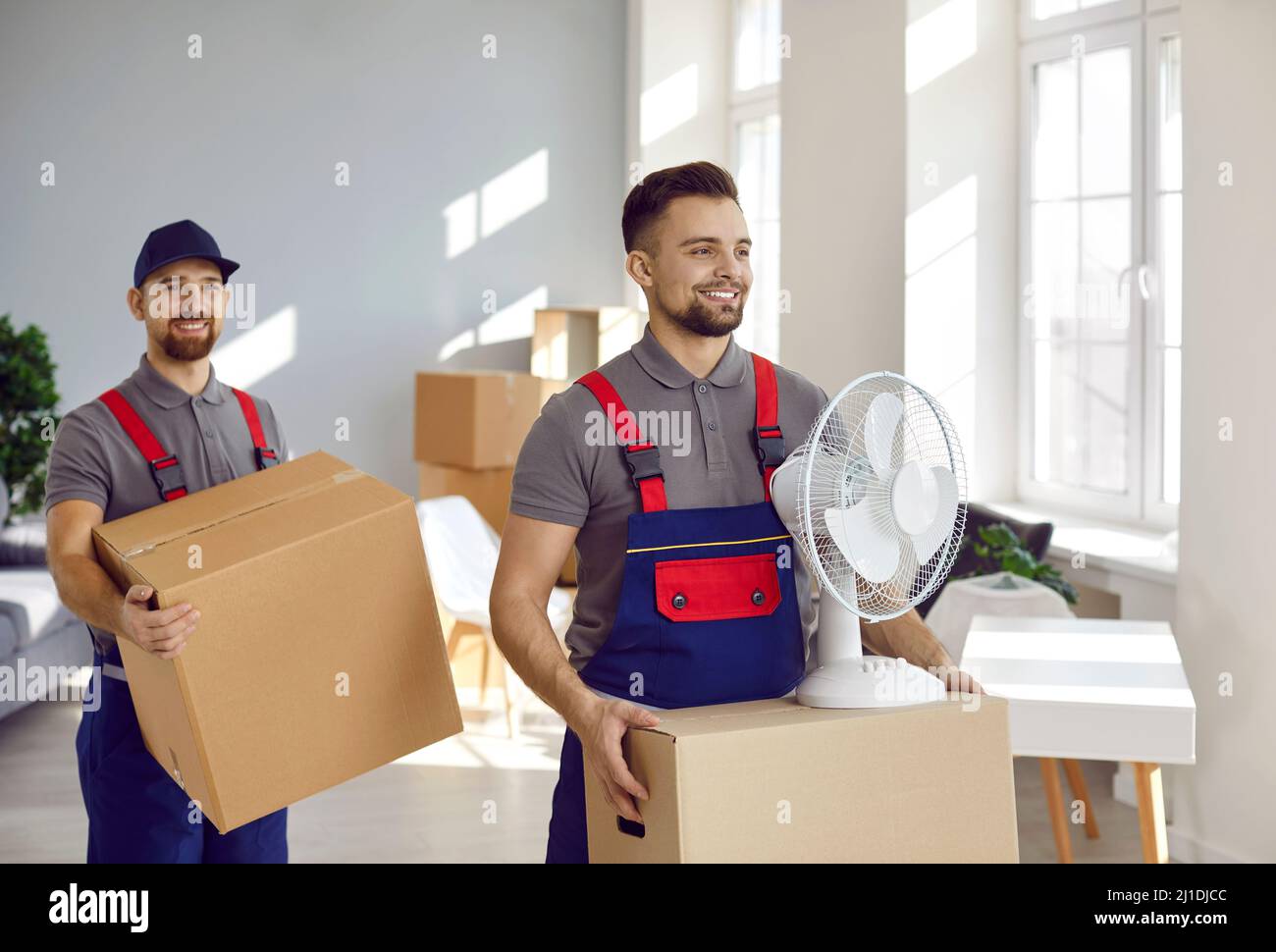 Les portiers de service mobile transportent des boîtes en carton avec des objets et des appareils ménagers. Banque D'Images