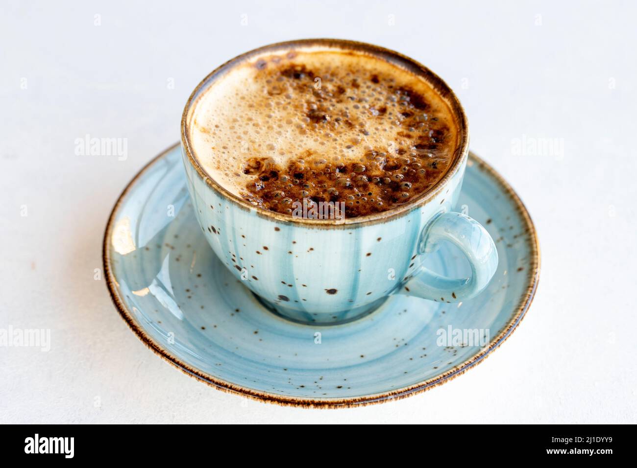 Café au lait sur fond blanc. Tasse de café avec du lait sur la table. Gros plan Banque D'Images