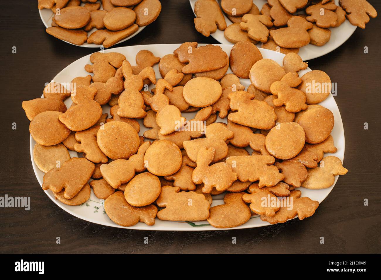 Biscuits de pain d'épice de Pâques faits main dans une assiette blanche sur une table sombre.symboles printaniers faits de pain d'épice.biscuits faits maison.lapin de Pâques, lapin, œufs et du Banque D'Images