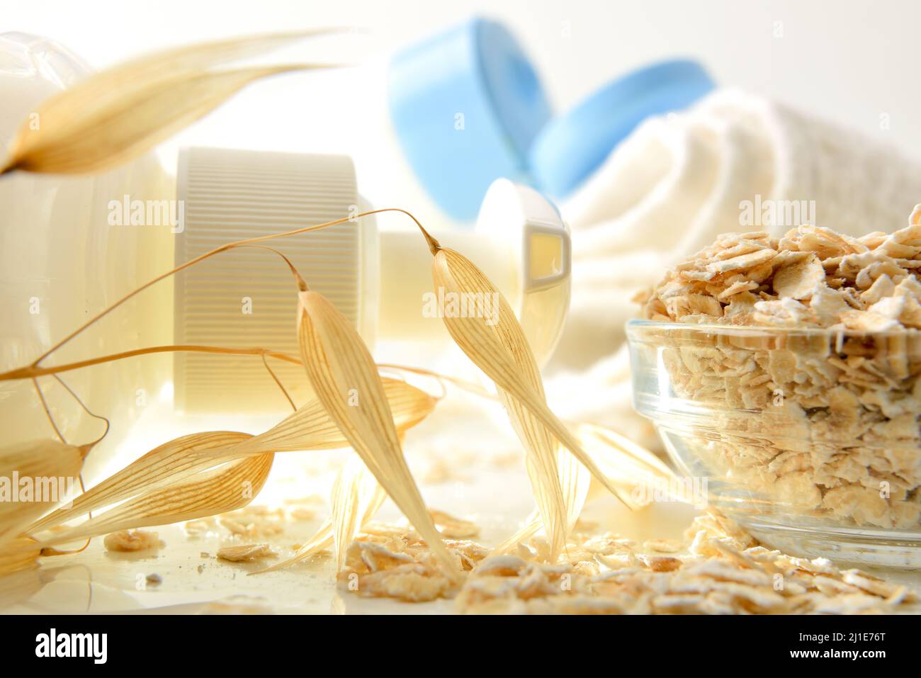 Détail des produits de bain avec extrait d'avoine sur table blanche avec pailles. Vue avant. Composition horizontale. Banque D'Images