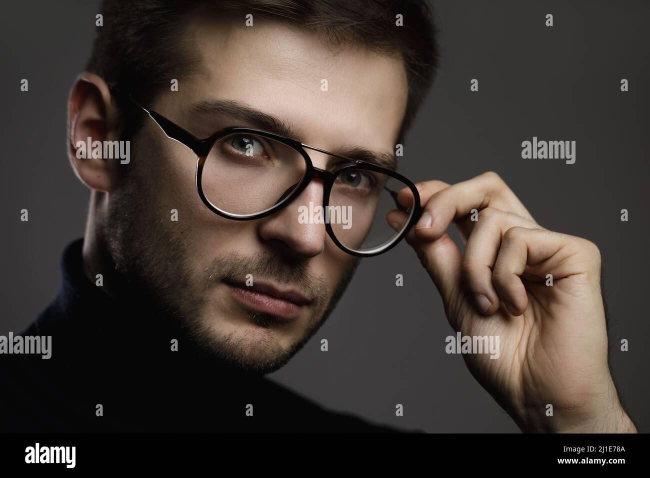 Jeune homme élégant portant des lunettes et un col roulé Banque D'Images