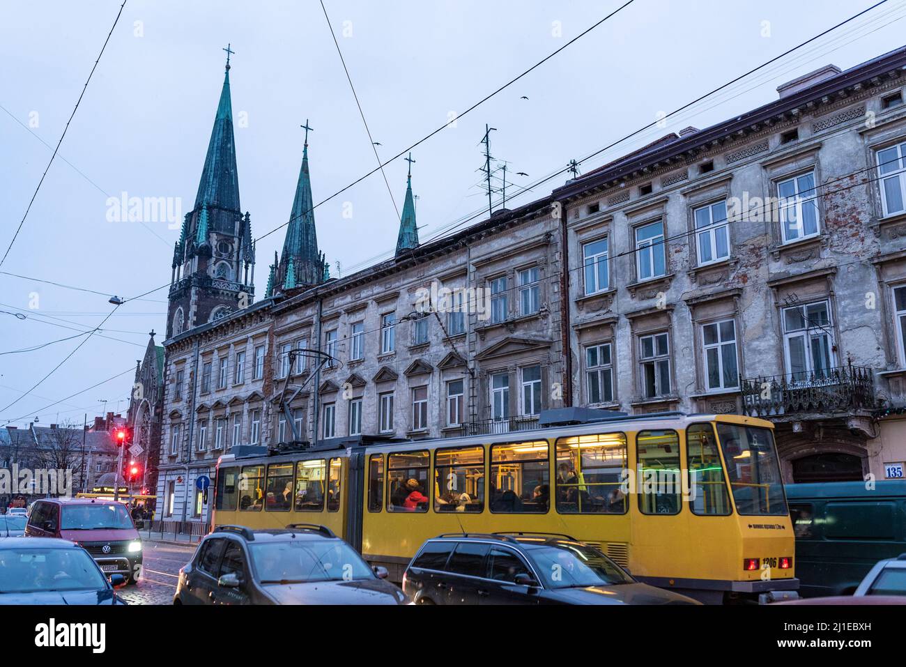 11 mars 2022, Lviv, Ukraine. Tramway de Lviv les transports publics sont vus dans la circulation dans le centre-ville avec monument et église en arrière-plan Banque D'Images