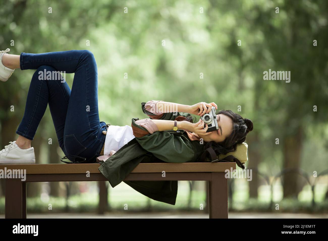 Jeune touriste femelle couché sur un banc de prendre des photos - photo de stock Banque D'Images