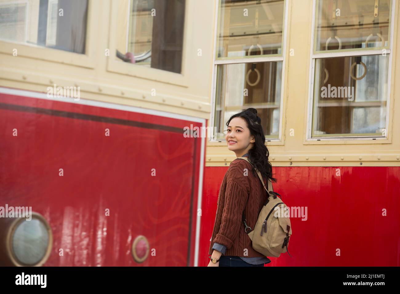 Jeune touriste se tenant entre deux vieux trams lents - photo de stock Banque D'Images