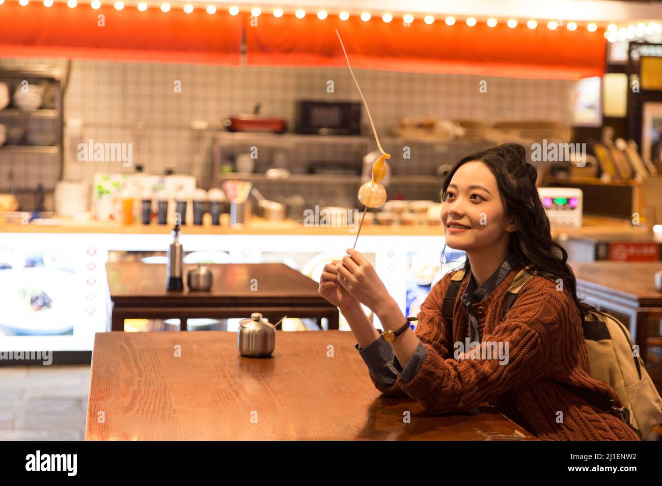 Jeune femme routard admirant le sucre de calabash dans un snack de minuit à Beijing - photo de stock Banque D'Images