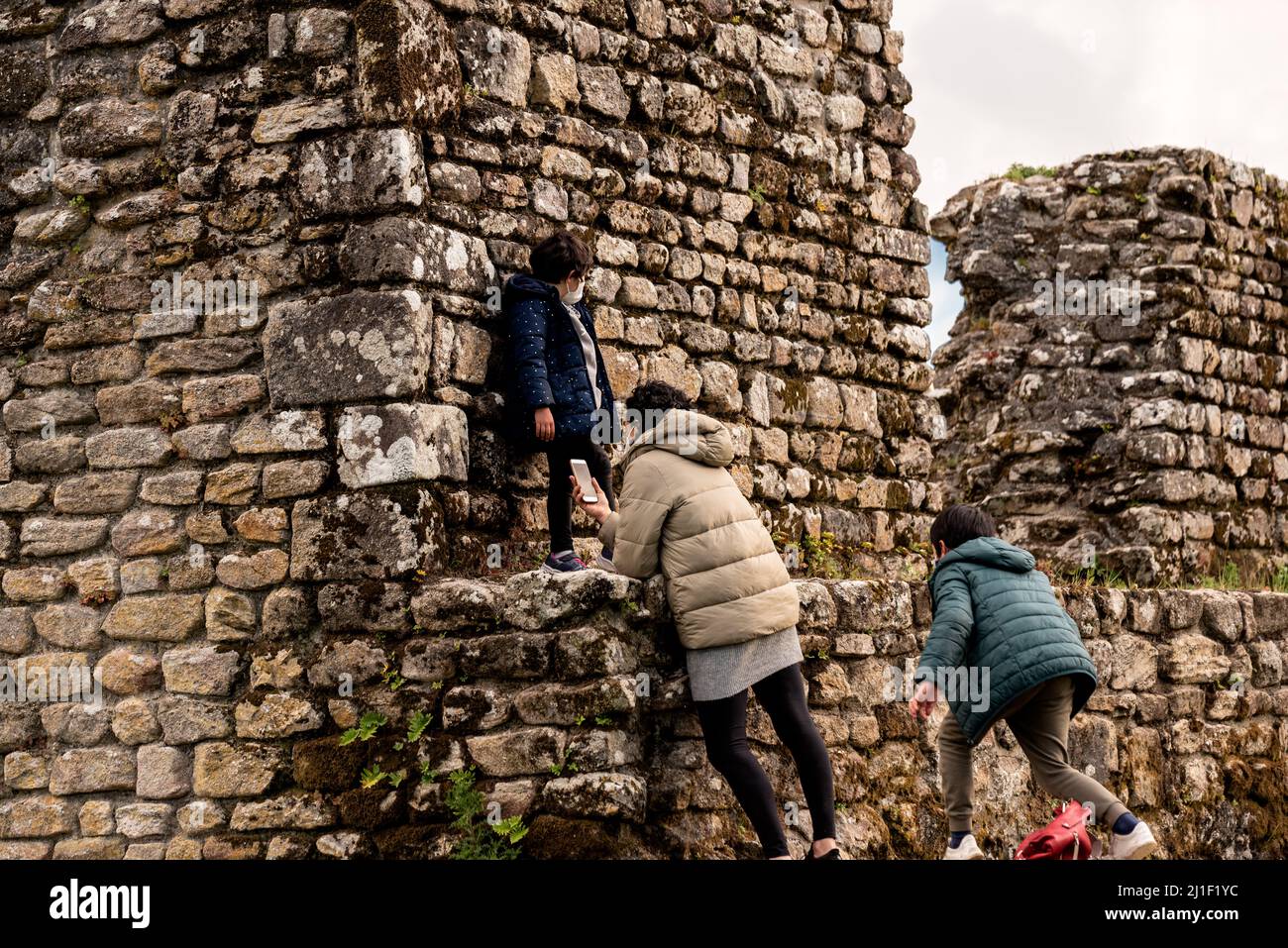 Famille caucasienne explorant les ruines de tours à Catoira, Espagne Banque D'Images