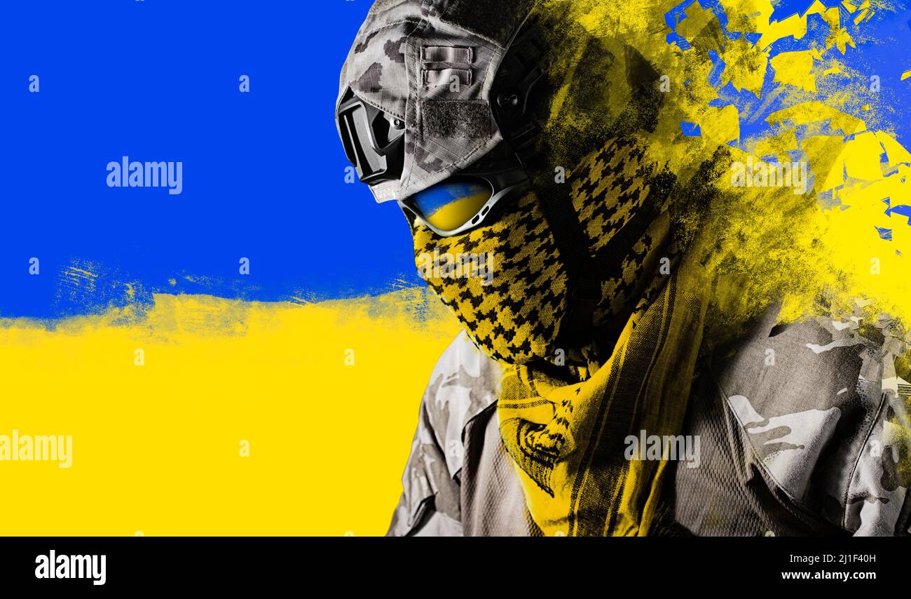 Photo d'un militaire ukrainien entièrement équipé en uniforme sur fond de drapeau national. Banque D'Images