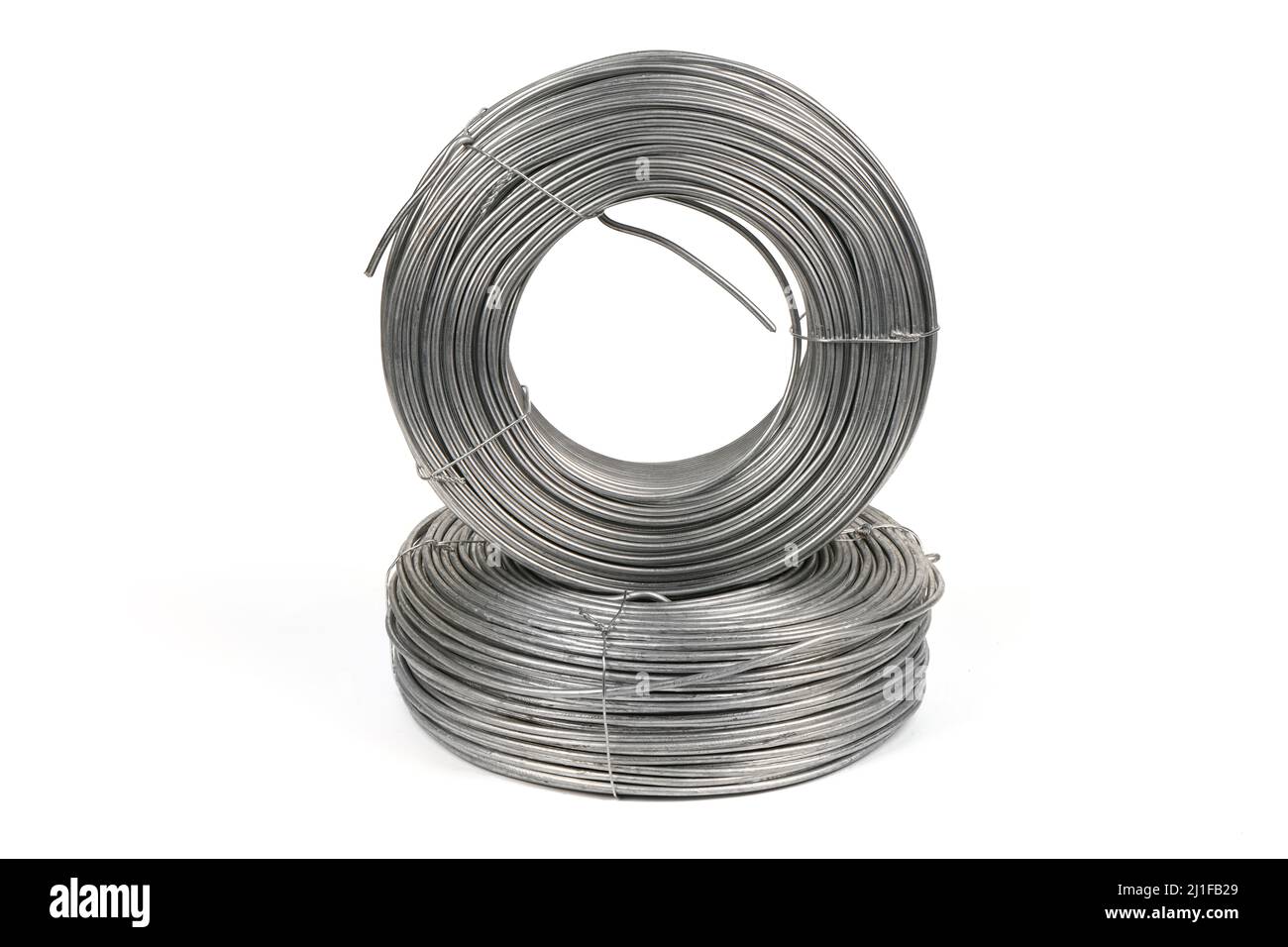 Deux bobines de fils galvanisés reposant sur un fond blanc. Photo haute résolution. Profondeur de champ complète. Banque D'Images