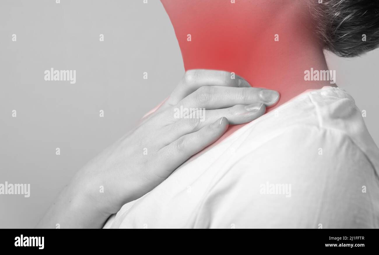 Mal de gorge. Femme main tenant le cou douloureux avec point rouge gros  plan. De. Concept des soins de santé, de la médecine, de la maladie.  Grippe, rhume, inflammation. Noir et blanc.