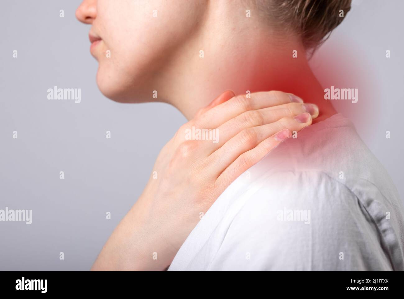 Douleurs au cou. Femme main tenant le cou douloureux avec point rouge gros plan. Spasme musculaire, blessure, traumatisme ou posture gênante. Soins de santé, concept de médecine. Photo de haute qualité Banque D'Images
