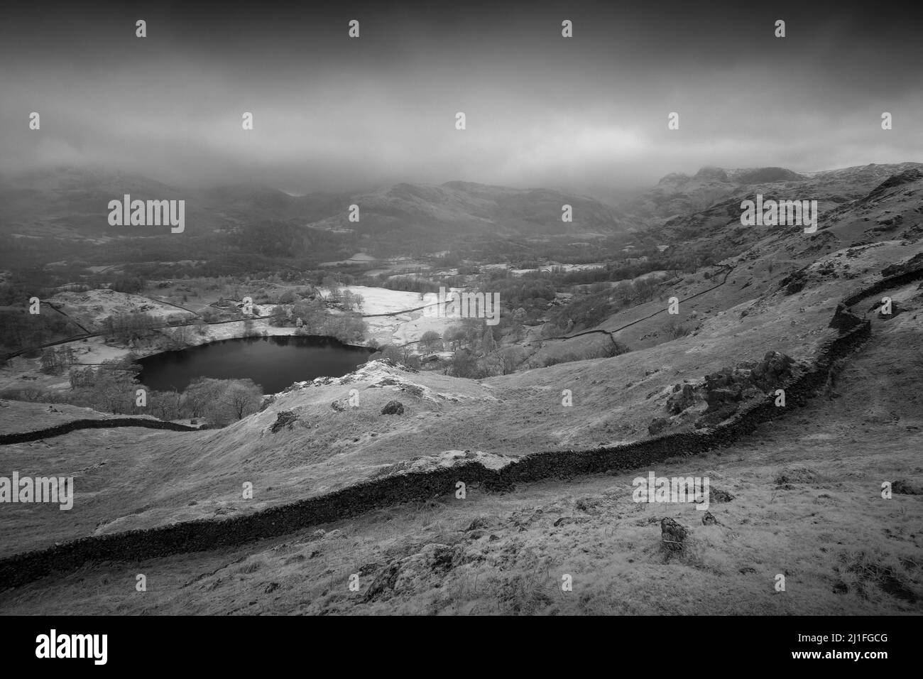 Une image en noir et blanc de Loughrigg Tarn de Loughrigg est tombée dans le parc national de Lake District, Cumbria, Angleterre. Banque D'Images
