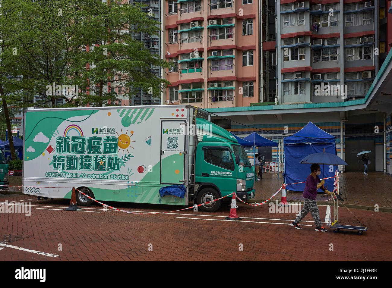 Hong Kong, Chine. 25th mars 2022. Une femme passe devant un camion mobile de poste de vaccination Covid-19 à Tin Shui Wai à Hong Kong. Crédit : SOPA Images Limited/Alamy Live News Banque D'Images