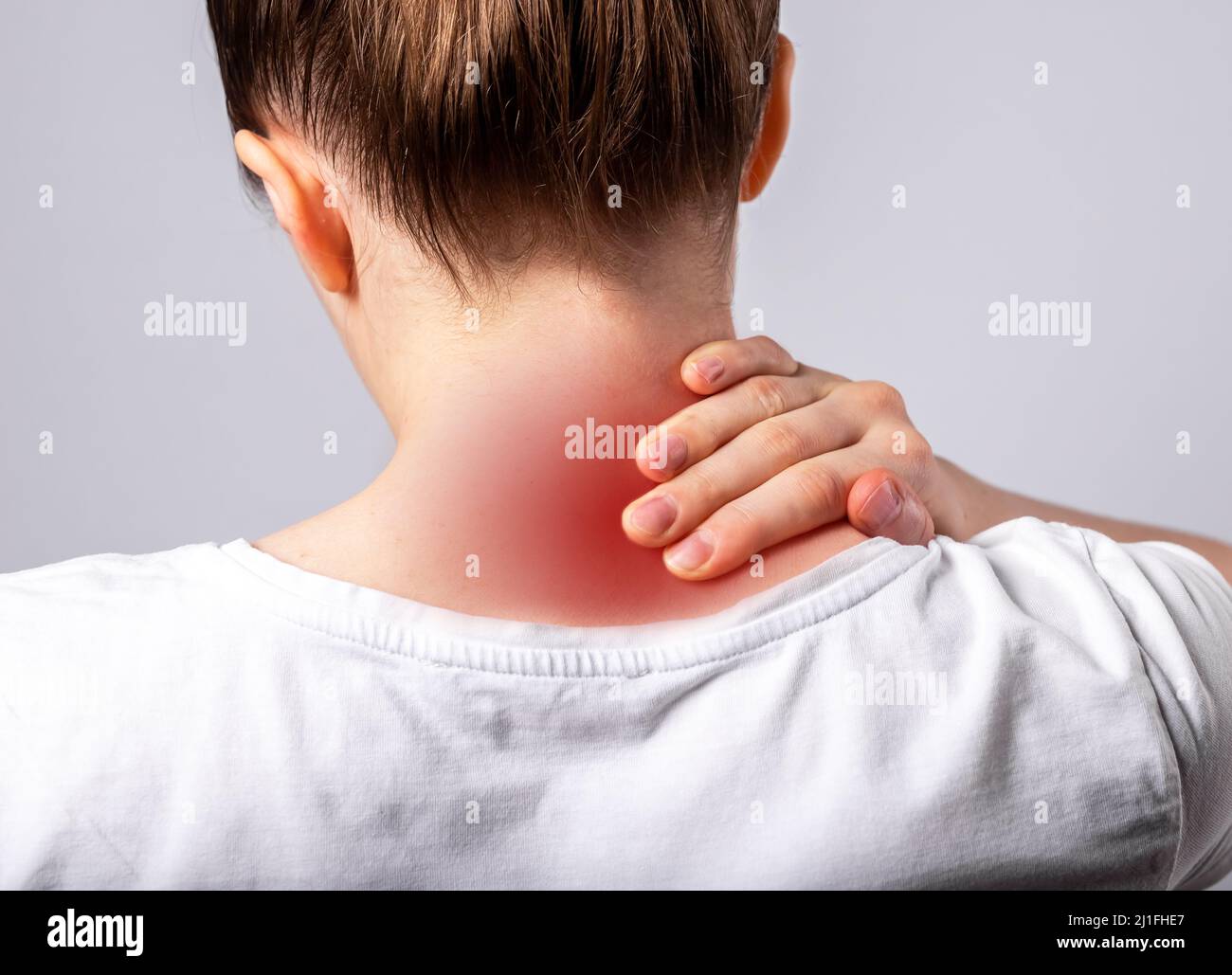 Femme souffrant de douleurs au cou. Main tenant le cou douloureux avec tache rouge gros plan. Spasme musculaire. Soins de santé, concept de médecine. Mode de vie sédentaire. Photo de haute qualité Banque D'Images