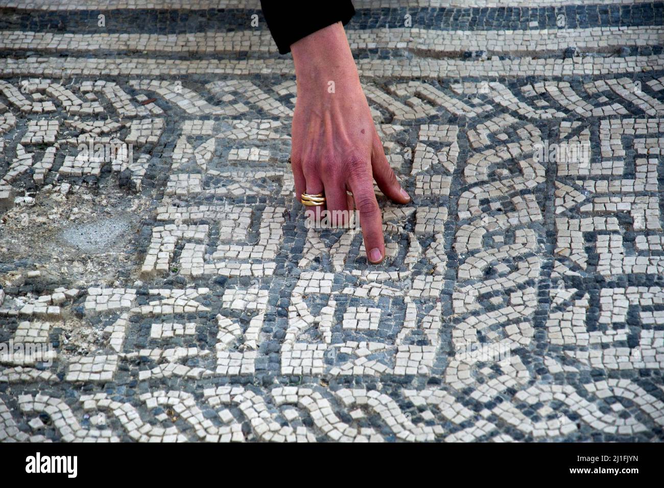 Ercolano, Italie. 25th mars 2022. La main d'un archéologue indique le sol en mosaïque précieux, lors de l'ouverture aux touristes de la 'Casa Della Gemma', un joyau du parc célèbre pour ses mosaïques de sol précieuses. Ercolano, Italie, 25 mars 2022. (Photo par Vincenzo Izzo/Sipa USA) crédit: SIPA USA/Alay Live News Banque D'Images