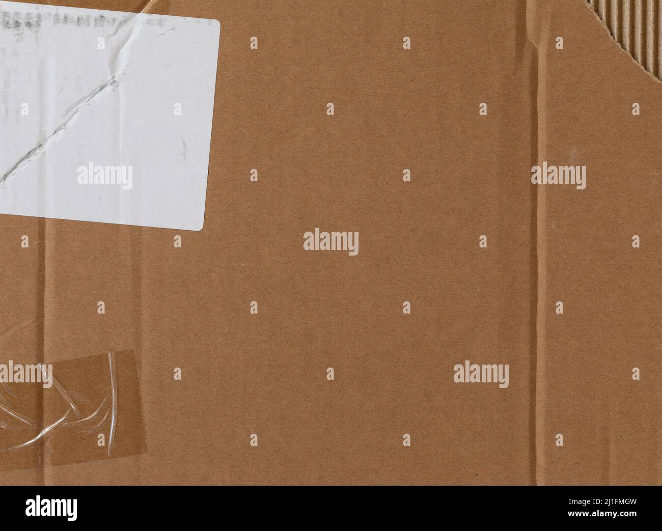 Texture de carton usée avec ruban transparent, autocollant blanc et partie déchirée Banque D'Images