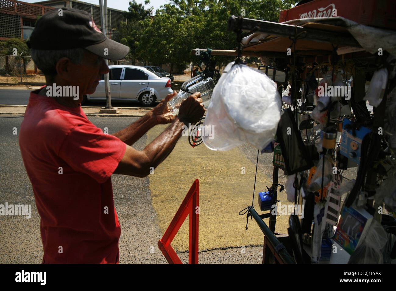 Le vénézuélien Luis Quintero marche dans les rues avec sa bicyclette modifiée chargée avec des produits de quincaillerie, à vendre aujourd'hui jeudi 25 mars 2022 dans la ville Banque D'Images