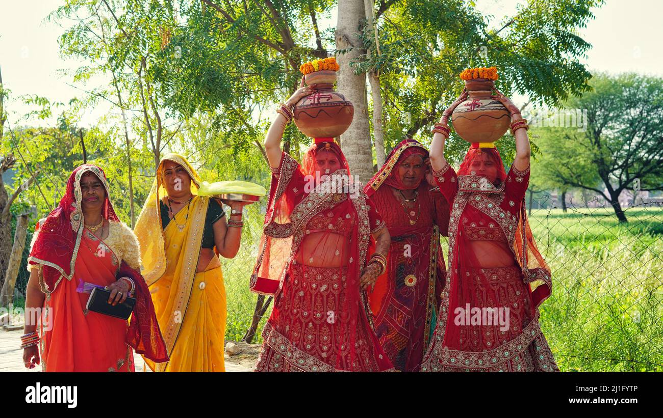 23 mars 2022 Reengus, Rajasthan, Inde. Concept de religion hindoue. Les femmes indiennes traditionnelles tiennent Clay Kalash à la tête d'un festival hindou Banque D'Images